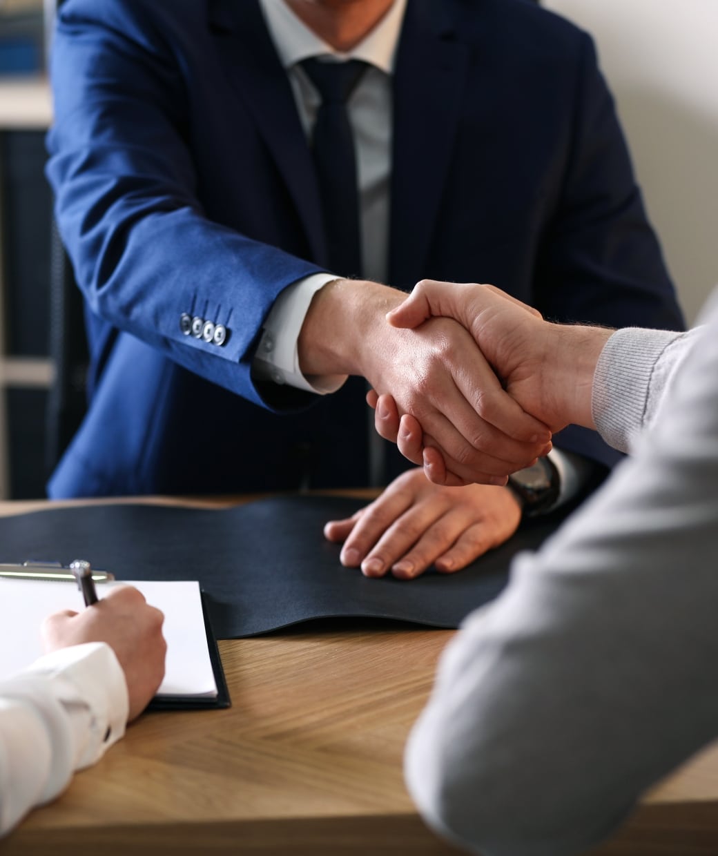 People shaking hands and signing paperwork